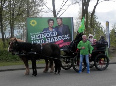 Vor dem grünen Großflächenplakat am ZOB